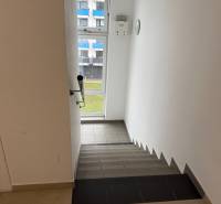 2-izbový byt novostavba s podzemným parkovaním- bez rezervačnej zálohy - Schodisko s výhľadom na okno v budove, biela stena, dlažba.