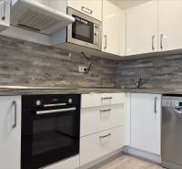 2-izbový byt novostavba s podzemným parkovaním- bez rezervačnej zálohy - Kuchynská linka v 2-izbovom byte so spotrebičmi a obkladom v drevenom dekore.