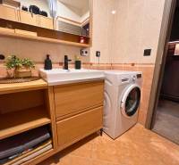 2-izbový byt v Pezinku s vlastným parkovaním - REZERVOVANÉ - Kúpeľňa v 2-izbovom byte s práčkou, skrinkou, umývadlom a zrkadlom.