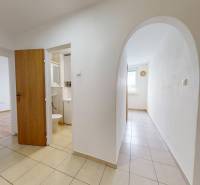 Na prenájom 2 izbový byt, Dežerice - Chodba v 2-izbovom byte s dlažbou a výhľadom na izbu s podlahou s dreveným dekorom.