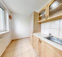 Na prenájom 2 izbový byt, Dežerice - Kuchyňa v 2-izbovom byte s dlažbou, drevodekorom a oknom.