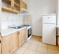 Na prenájom 2 izbový byt, Dežerice - Kuchyňa v 2-izbovom byte s kachličkami a dreveným dekorom skríň a spotrebičmi.