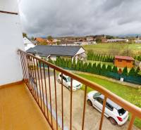 Na prenájom 2 izbový byt, Dežerice - Výhľad z balkóna 2-izbového bytu v Dežericiach s parkovaním a záhradou v pozadí.