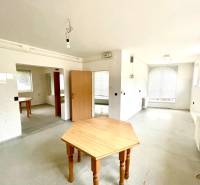 Záhorská Bystrica: Predaj domu kombinácia bývanie/podnikanie - Priestranná izba s drevenými stolmi a radiátormi v rodinnom dome.