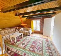 Predaj rekreačná chata s pozemkom, garážou a saunou Modra, Harmónia - Podkrovie chaty s dreveným stropom, pruhovanou sedačkou a závesným hojdacím kreslom.