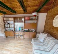 Predaj rekreačná chata s pozemkom, garážou a saunou Modra, Harmónia - Interiér chaty s drevenými trámami, nábytkom a podlahou s dreveným dekorom.