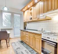 Na prenájom veľký 4-izbový byt s balkónom, garážou a záhradou, Kolta – - Kuchyňa v 4-izbovom byte s podlahou s dreveným dekorom a jedálenským stolom.