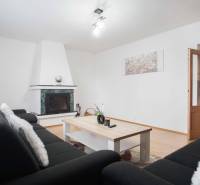 Na prenájom veľký 4-izbový byt s balkónom, garážou a záhradou, Kolta – - Obývacia izba v 4-izbovom byte s krbom a podlahou s dreveným dekorom.