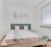 Na prenájom veľký 4-izbový byt s balkónom, garážou a záhradou, Kolta – - Spálňa so svetlou posteľou, podlahou s dreveným dekorom a ozdobnými obrazmi v 4-izbovom byte.