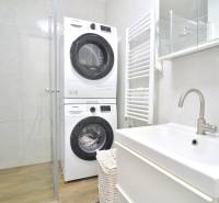 ŠTÚROVA, 3-i byt, 75 m2 – komplet rekonštrukcia, vlastné parkovanie - Kúpeľňa s práčkou a sušičkou v 3-izbovom byte s podlahou s dreveným dekorom.