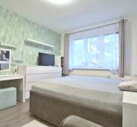 ŠTÚROVA, 3-i byt, 75 m2 – komplet rekonštrukcia, vlastné parkovanie - Spálňa v 3-izbovom byte s podlahou s dreveným dekorom a zelenou tapetou.