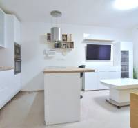 ŠTÚROVA, 3-i byt, 75 m2 – komplet rekonštrukcia, vlastné parkovanie - Kuchyňa a obývacia izba v 3-izbovom byte s bielym nábytkom a ostrovom.