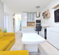 ŠTÚROVA, 3-i byt, 75 m2 – komplet rekonštrukcia, vlastné parkovanie - Obývacia izba v 3-izbovom byte s kuchyňou, žltou sedačkou a televízorom na stene.