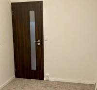 Prenájom 3 izbový byt, ulica Jána Poničana, BA IV. Devínska Nová Ves - Izba v 3-izbovom byte s kobercovou podlahou a tmavými dverami.