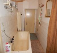  Na predaj 3 izbový dom v Kravanoch nad Dunajom s garážou . - Kúpeľňa v rodinnom dome so staršou vaňou a obkladom na stenách.