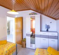 Na predaj krásny priestranný dom / 101 m²/ výhľadom na more  Čiovo - Spálňa v Rekreačnom apartmáne s farebným obliekaním, skrinkou a dekoráciami na stene.