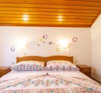 Na predaj krásny priestranný dom / 101 m²/ výhľadom na more  Čiovo - Spálňa v Rekreačnom apartmáne s posteľou a dekoráciami na bielej stene.