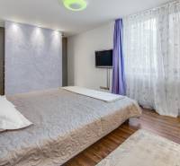 Novostavba 3 izbový byt, Palisády, 147 m2, výhľad, parkovanie, BA I - Spálňa v 3-izbovom byte s posteľou, televíziou a pretekajúcimi závesmi na okne.