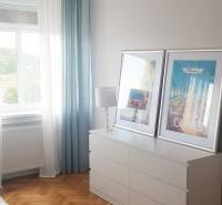 Nádherný, staromestský, 1-izb. byt v centre s výhľadom na Dunaj - Spálňa v 1-izbovom byte so skrinkou, lustrom a podlahou s dreveným dekorom.