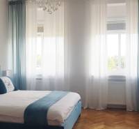 Nádherný, staromestský, 1-izb. byt v centre s výhľadom na Dunaj - Spálňa s manželskou posteľou, obrazmi a podlahou s dreveným dekorom v 1-izbovom byte.