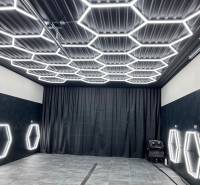 Ponuka na odstupenie detailingového štúdia a autoumyvárne v Prievidzi - Obchodné priestory s tmavým dekorom a šesťuholníkovým LED osvetlením na strope a stenách.