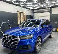 Ponuka na odstupenie detailingového štúdia a autoumyvárne v Prievidzi - Audi SUV v obchodných priestoroch s kachličkovou podlahou a geometrickými stropnými svetlami.