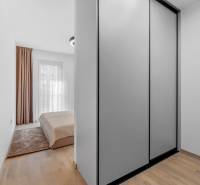 I Prenájom exkluzívneho 2-i bytu v projekte Metropolis - Spálňa v 2-izbovom byte so vstavanou skriňou a podlahou s dreveným dekorom.