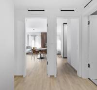 I Prenájom exkluzívneho 2-i bytu v projekte Metropolis - Interiér 2-izbového bytu s podlahou s dreveným dekorom, pohľad na obývačku a spálňu.