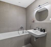 I Prenájom exkluzívneho 2-i bytu v projekte Metropolis - Kúpeľňa v 2-izbovom byte so sprchou, umývadlom a kruhovým zrkadlom.