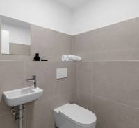 I Prenájom exkluzívneho 2-i bytu v projekte Metropolis - Kúpeľňa v 2-izbovom byte s umývadlom, toaletou a béžovým obkladom.
