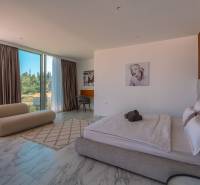 NA PREDAJ Luxusná vila  /360 m²/ s infinity bazénom, mesto Korčula - Spálňa vo vile s veľkými oknami a mramorovou podlahou, so štýlovým nábytkom.