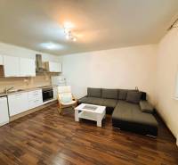 Prenájom 2 izbový byt – 52 m², lokalita – Malá Paka. - Obývacia izba v 2-izbovom byte s rohovo umiestnenou sedačkou a kuchynskou linkou.
