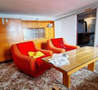 Rodinný dom v obci Borskom Mikuláš. - Obývacia izba v rodinnom dome so staršími kreslami, stolom a presklenou skriňou.