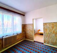 Rodinný dom v obci Borskom Mikuláš. - Interiér rodinného domu s dlažbou, radiátorom a oknom s záclonou.