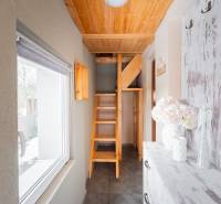 Záhradná chatka Handlová - Interiér chaty s dreveným schodiskom a oknom s výhľadom na exteriér.