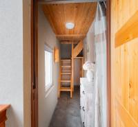 Záhradná chatka Handlová - Svetlá chodba v chate s drevenými schodmi a dekoratívnymi prvkami.