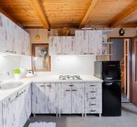 Záhradná chatka Handlová - Kuchyňa v chate s dreveným stropom a vintage skriňami, útulné vybavenie.