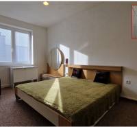 AstonReal: EXKLUZÍVNE predaj rodinný dom Spišská Nová Ves - Ferčekovce - Spálňa s dvojlôžkom, zelenou prikrývkou, nočným stolíkom a zrkadlom v rodinnom dome.