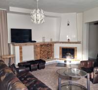 AstonReal: EXKLUZÍVNE predaj rodinný dom Spišská Nová Ves - Ferčekovce - Obývacia izba s kozubom v rodinnom dome, kožené kreslo a konferenčný stolík.