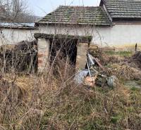 Predám pozemok v obci Dubník okr. Nové Zámky - Opustená budova na pozemku v Dubníku s neudržovaným okolím a starými strechami.