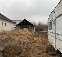 Predám pozemok v obci Dubník okr. Nové Zámky - Dvor v Dubníku na ulici Dubník vhodný na pozemky - bývanie s pohľadom na budovy a karavan.