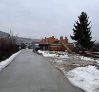 Novostavba - rodinný dom vo Višňovom pri Žiline - Stavenisko rodinného domu vo Višňovom na Višňovej ulici so zasneženým okolím a stromom.