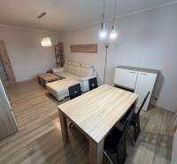 PRENÁJOM Trojizbový zariadený byt, Žilina - Vlčince - Obývacia izba s podlahou s dreveným dekorom, pohovkou a stolom v 3-izbovom byte.