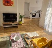 Viacgeneračný rodinný dom / investičná nehnuteľnosť – Dolná časť Zobor - Obývacia izba v rodinnom dome so sedačkou, televízorom a pohľadom na kuchyňu.