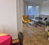 Viacgeneračný rodinný dom / investičná nehnuteľnosť – Dolná časť Zobor - Obývacia izba v rodinnom dome s oknom, žltým kreslom a stolíkom.