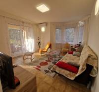 Viacgeneračný rodinný dom / investičná nehnuteľnosť – Dolná časť Zobor - Obývačka rodinného domu s televízorom, pohovkou, stolíkom a veľkými oknami s závesmi.