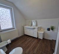 Viacgeneračný rodinný dom / investičná nehnuteľnosť – Dolná časť Zobor - Kúpeľňa s podlahou s dreveným dekorom v rodinnom dome, vybavená WC, umývadlom a vaňou.