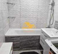 Prenajmem 3 izbový byt s loggiou v Nových Zámkoch - Kúpeľňa v 3-izbovom byte s vaňou, sprchou a práčkou na bielych obkladoch.