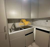 Prenajmem prerobený 2 izbový byt s balkónom v Nových Zámkoch - Kuchyňa v 2-izbovom byte s mramorovou doskou a sivými skrinkami.