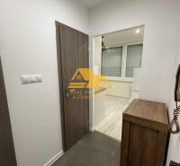 Prenajmem prerobený 1 izbový byt v Nových Zámkoch - Interiér 1-izbového bytu s dlažbou a podlahou s dreveným dekorom.